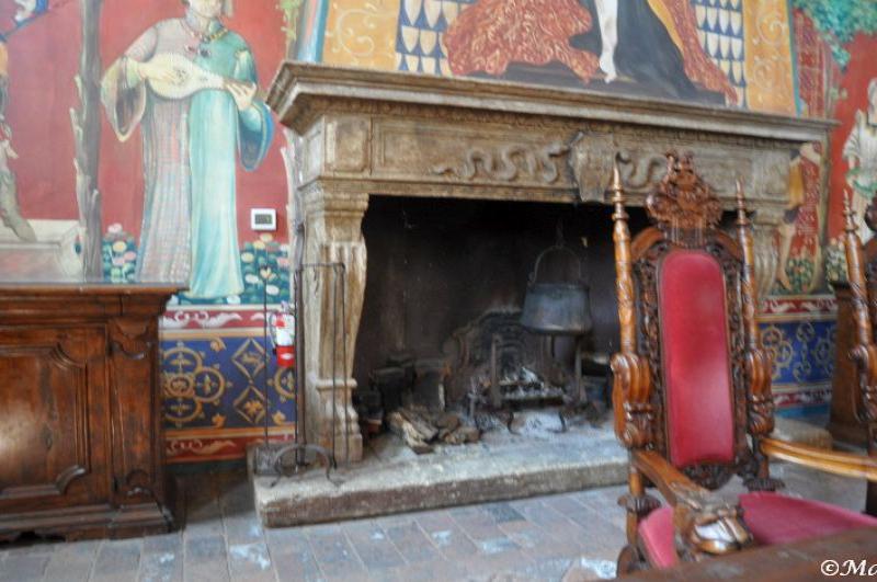Castello Di Amorosa: камин с резными креслами и фресками в стиле средневековой Италии